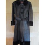 A retro black leather ladies, full length coat with faux fur hem, cuffs and collar having oriental