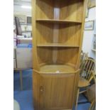 An Ercol corner display unit having two shelves above a single cupboard door