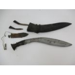A Gurkha style kukri with a carved wooden handle with a leather covered sheath, two accessory knives
