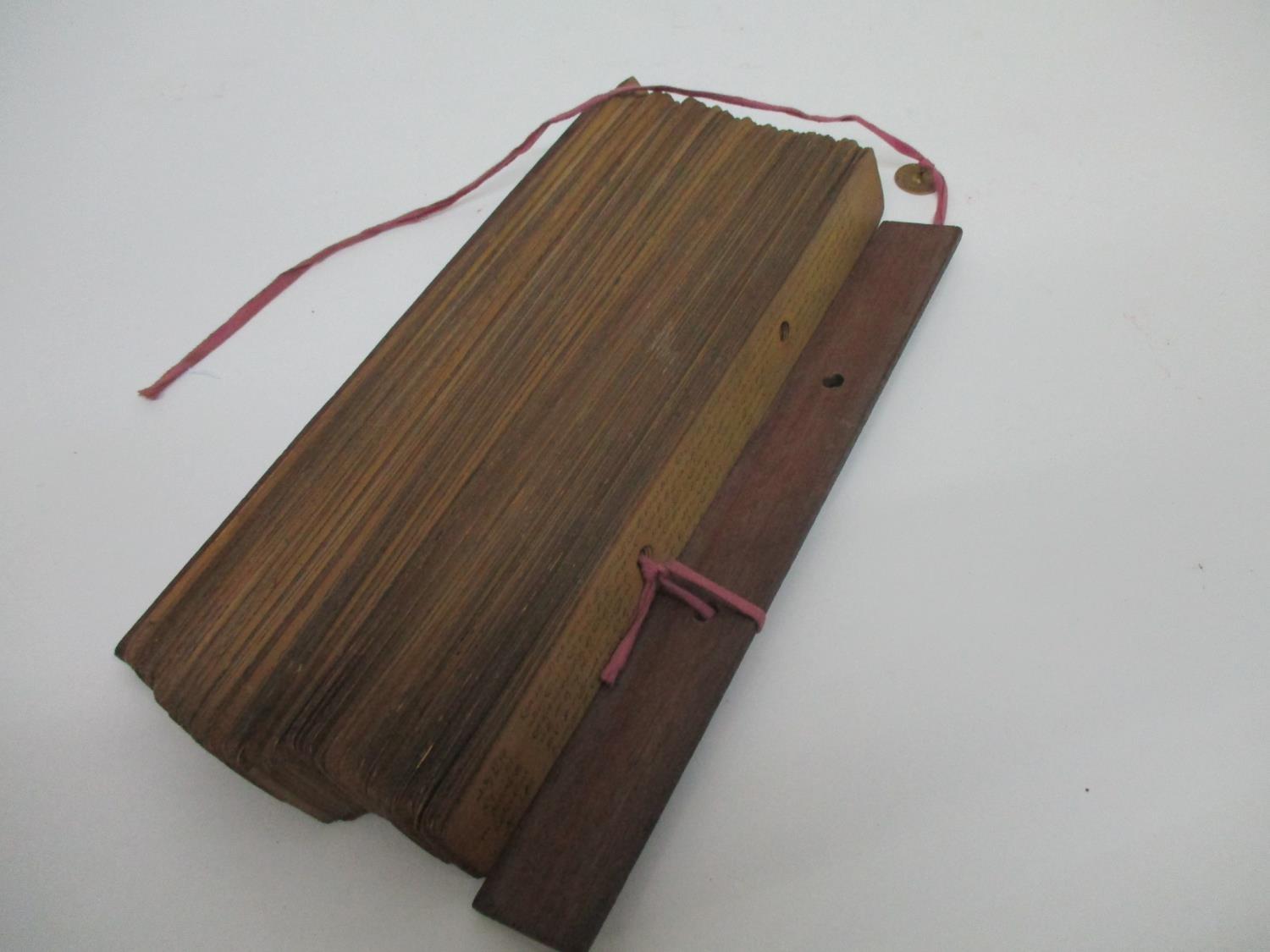 A 19th century South East Asian Buddhist manuscript on palm leaves, with wooden covers, 11 1/2" l - Image 2 of 4