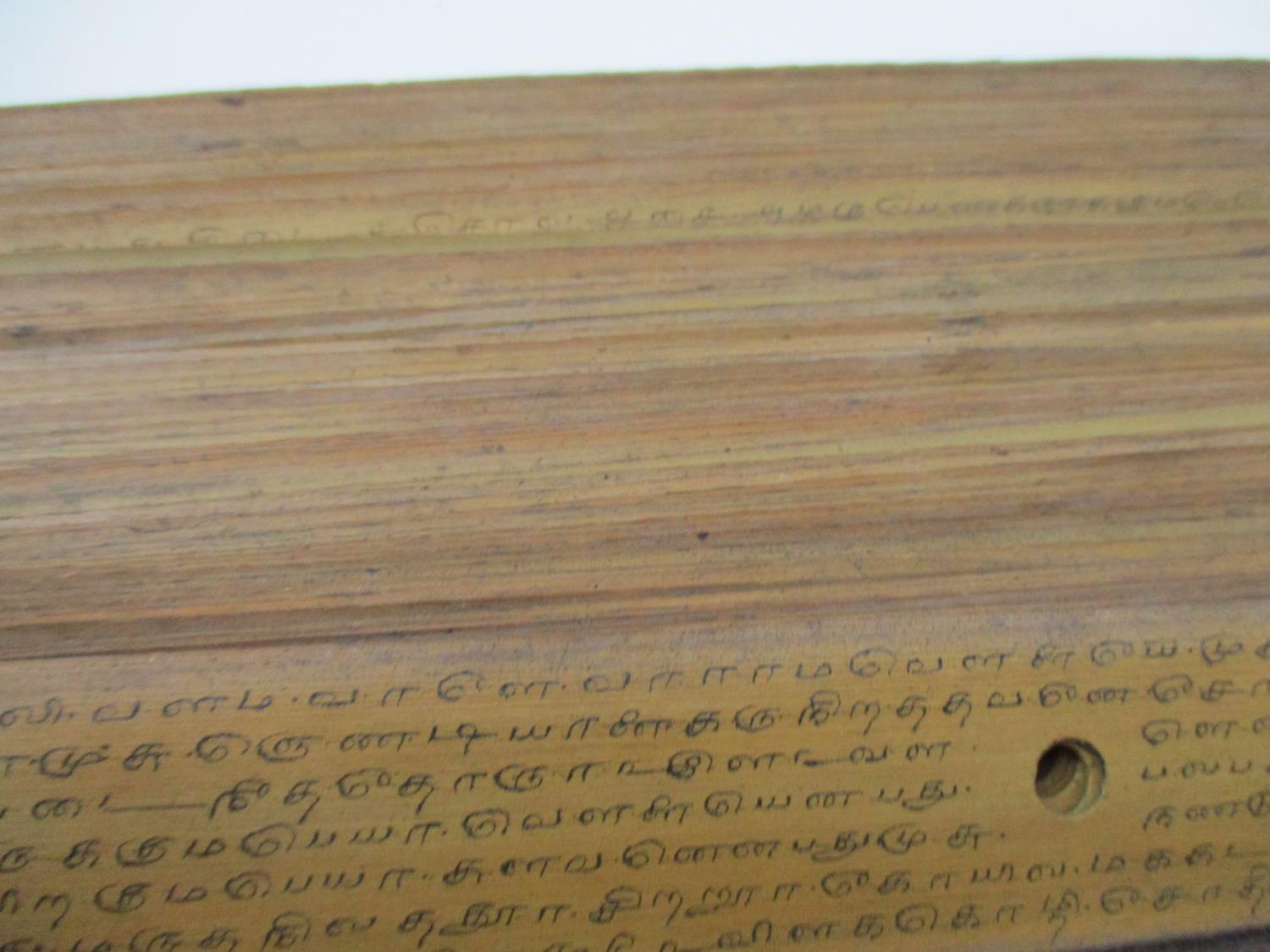 A 19th century South East Asian Buddhist manuscript on palm leaves, with wooden covers, 11 1/2" l - Image 4 of 4