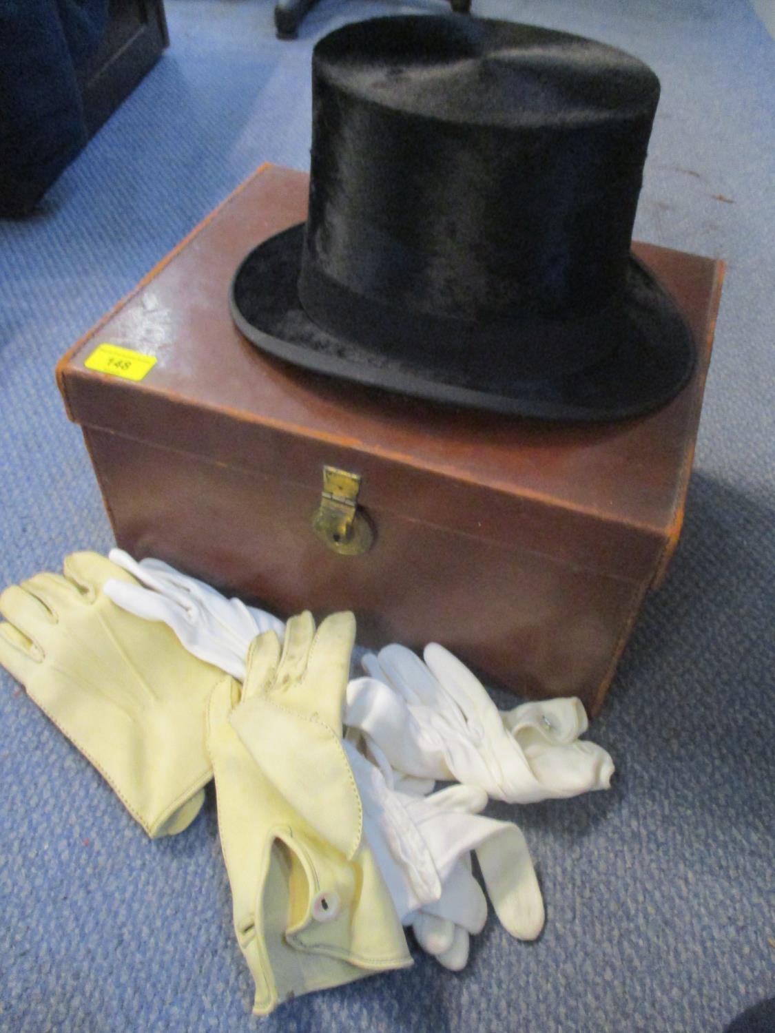 A top hat in a leather case, together with mixed gloves