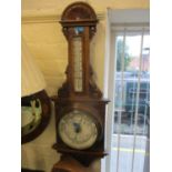 A Victorian carved oak cased android barometer with temperature gauge