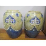 A pair of Royal Doulton ovoid vases having beaded borders and decorated with flower heads,