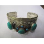 A white metal bangle inset with semi-precious stones