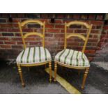 A pair of French gilt wood parlour chairs, upholstered seats on turned and fluted front legs