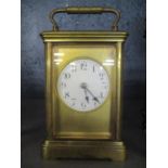 A late 19th/early 20th century French brass carriage clock having white enamel dial with Roman