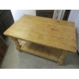 A low pine two tier coffee table raised on bun shaped feet, 17 3/4"h x 35 1/2"w