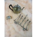 A white metal napkin ring, a bachelor's teapot and toast rack