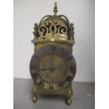 A 19th century brass lantern clock having engraved scroll decoration and surmounted by a bell