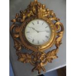 A 20th century gilt metal clock decorated with flowers amongst scrolls and having a Beretta 8 day