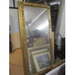 A large gilt framed mirror having a floral decorated border