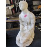 A white stone figure of a kneeling lady A/F