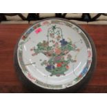 An 18th century Chinese famille vert charger decorated with a vase of flowers, heavily restored,