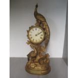 An early 20th century gilt metal clock in the form of a peacock amongst foliate