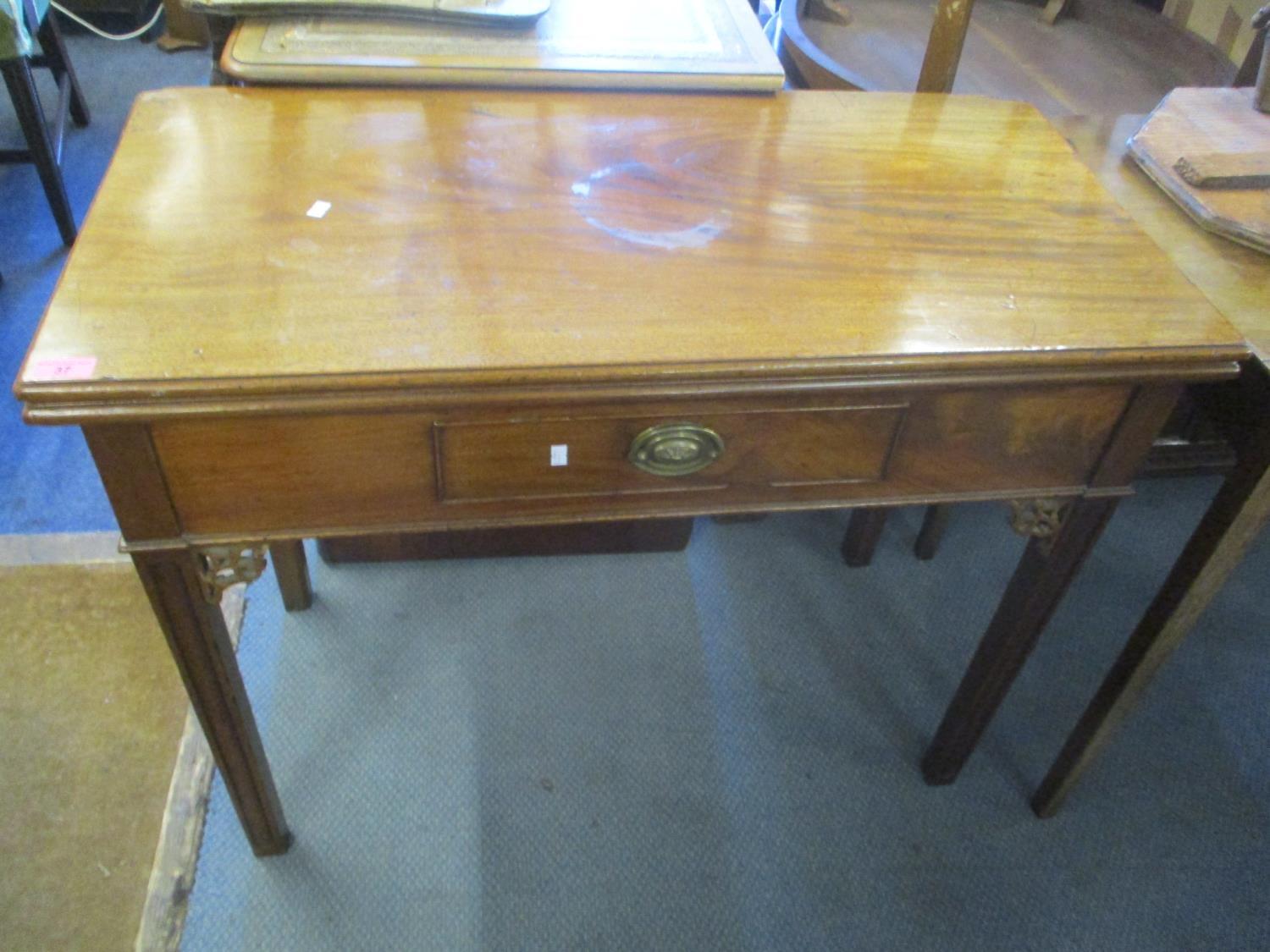 A Georgian mahogany tea table having a fold over top, single inset drawer and chamfered legs, 29"