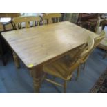 A pine kitchen table having an inset drawer and turned legs together with four splat back chairs