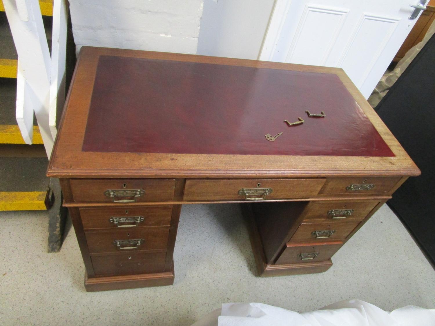 An early 20th century walnut, twin pedestal, nine drawer desk on castors