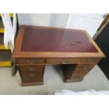 An early 20th century walnut, twin pedestal, nine drawer desk on castors