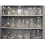 Seven shelves of glassware to include thirty four decanters and Edinburgh glass