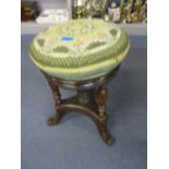 A late Victorian/early Edwardian revolving piano stool, with vase shaped turned columns on splayed