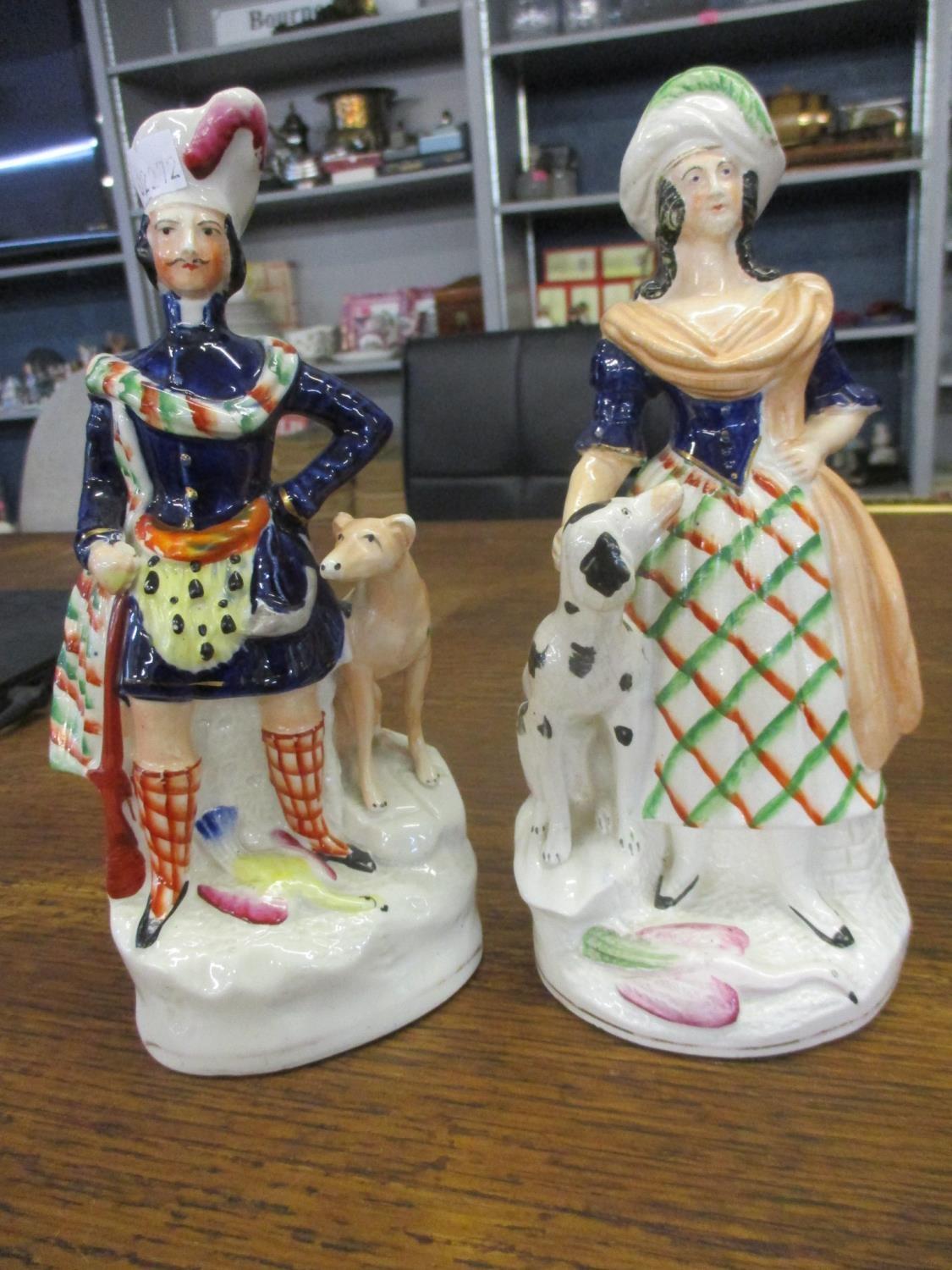 A pair of Staffordshire figures depicting male and female flanked by hounds