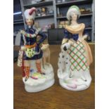 A pair of Staffordshire figures depicting male and female flanked by hounds