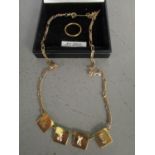 A gold necklace with four 18ct gold plaques on a 9ct gold chain and an 18ct yellow gold wedding band