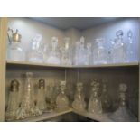 Two shelves consisting of thirty cut glass decanters, together with a silver plated tray