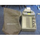 A vintage Burroughs adding machine and cover