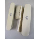 An Art Deco ivory three piece dressing table brush set, with initials to the top