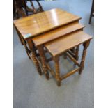 A nest of three oak tables with bobbin turned supports