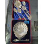 A silver shell shaped butter dish and silver and silver plated spoons