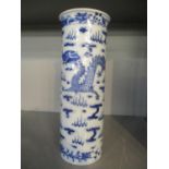 A late 19th century Chinese blue and white cylinder vase decorated with dragons and having four