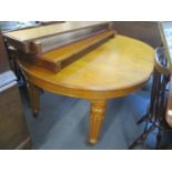 A walnut extending dining table on turned, tapered, reeded legs on castors with three additional