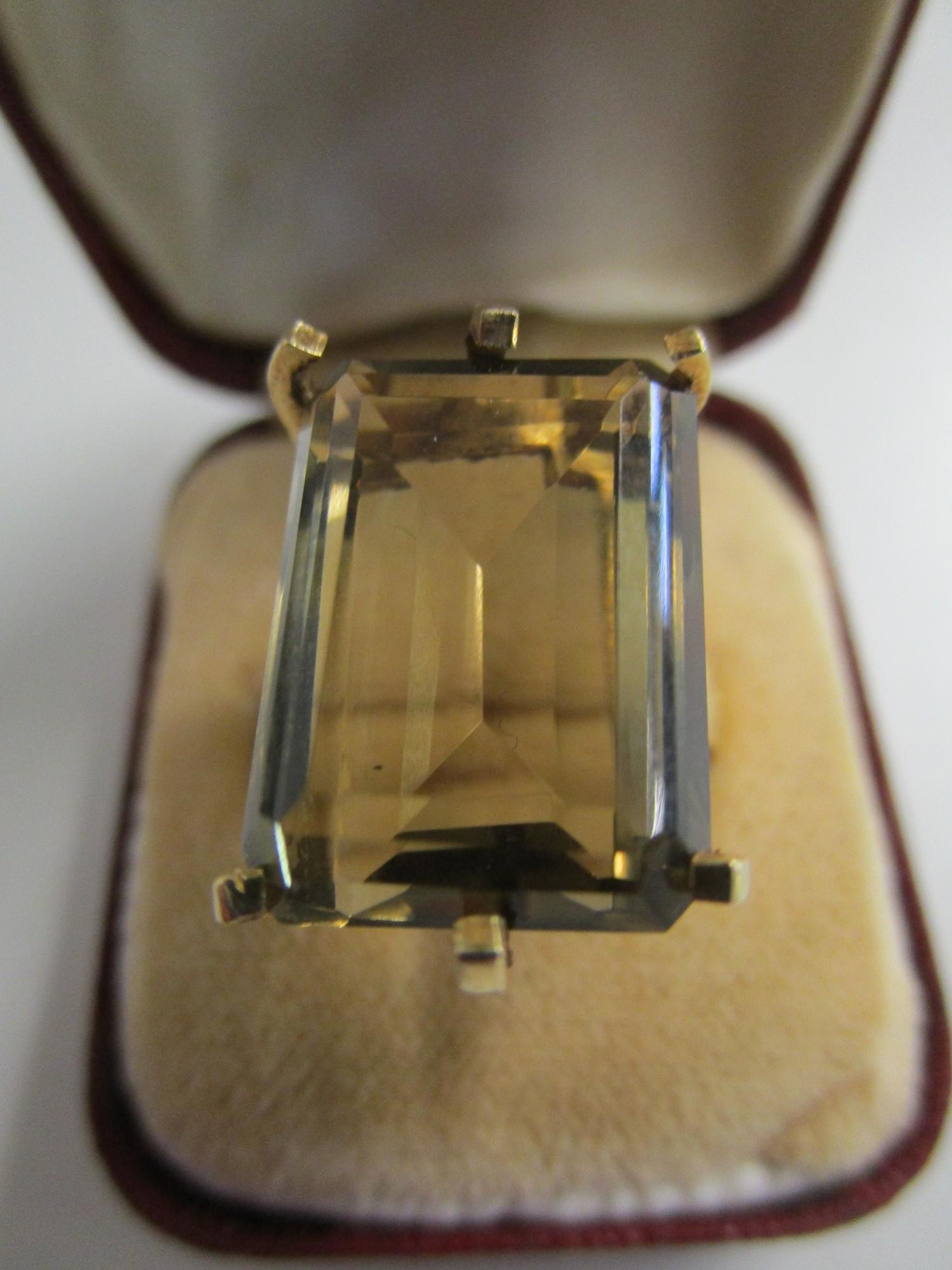 A gold coloured ring set with a large citrine, marks to exterior of shank