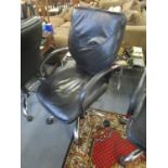 A faux black leather and chrome swivel office chair with arms and castors
