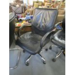 A faux black leather and chrome swivel office chair with arms and castors