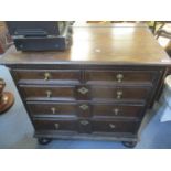 An 18th century and later oak chest of two short and three long drawers, standing on bun shaped