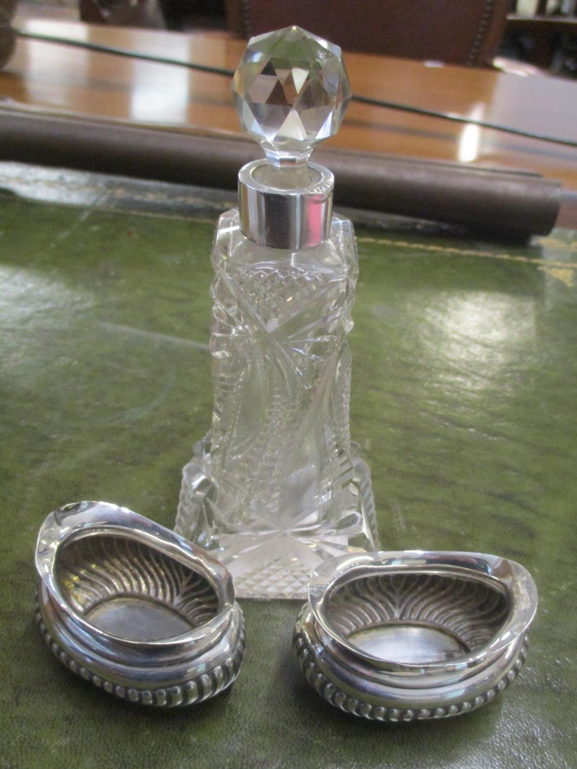 A cut glass silver topped scent bottle, together with two silver salts