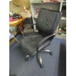 A faux black leather and chrome swivel office chair with arms and castors