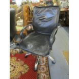 A faux black leather and chrome swivel office chair with arms and castors