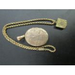 A Victorian gilded yellow metal, shield shaped pendant locket with floral engraved decoration and