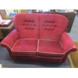 A two seater burgundy button back upholstered sofa