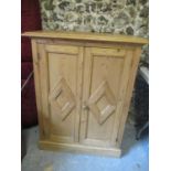 A 19th century and later pine twin door, panelled side cabinet fitted with shelves and on a plinth