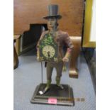 A reproduction clock in the form of a gent, mounted on a base