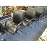 A set of four faux black leather office chairs with arms