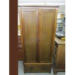 A contemporary hardwood wardrobe with twin doors, single base drawer and square feet 75" x 35" x