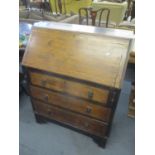 An early 20th century oak bureau having fall flap above three long drawers, 38 1/2"h x 30 1/2"w