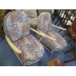 A pair of vintage blonde Ercol stick back armchairs